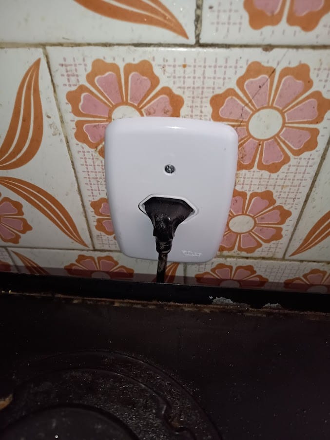 Tomada nova instalada em parede de azulejo